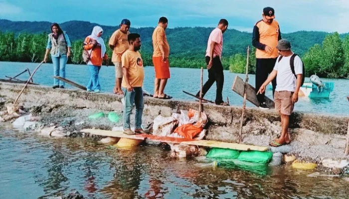 Kalak BPBD Kepulauan Sula, Hi. Buhari Buamona didampingi stafnya, melakukan peninjauan ke lokasi pascabanjir rob dan jebolnya tanggul Telaga Kabau.