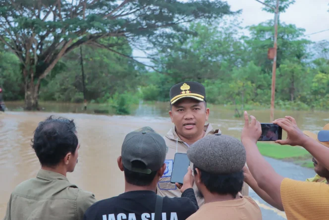 
Foto: Kapolres Kepulauan Sula, AKBP Kodrat Muh Hartanto saat diwawancari di lokasi banjir. (doc: istimewa)
